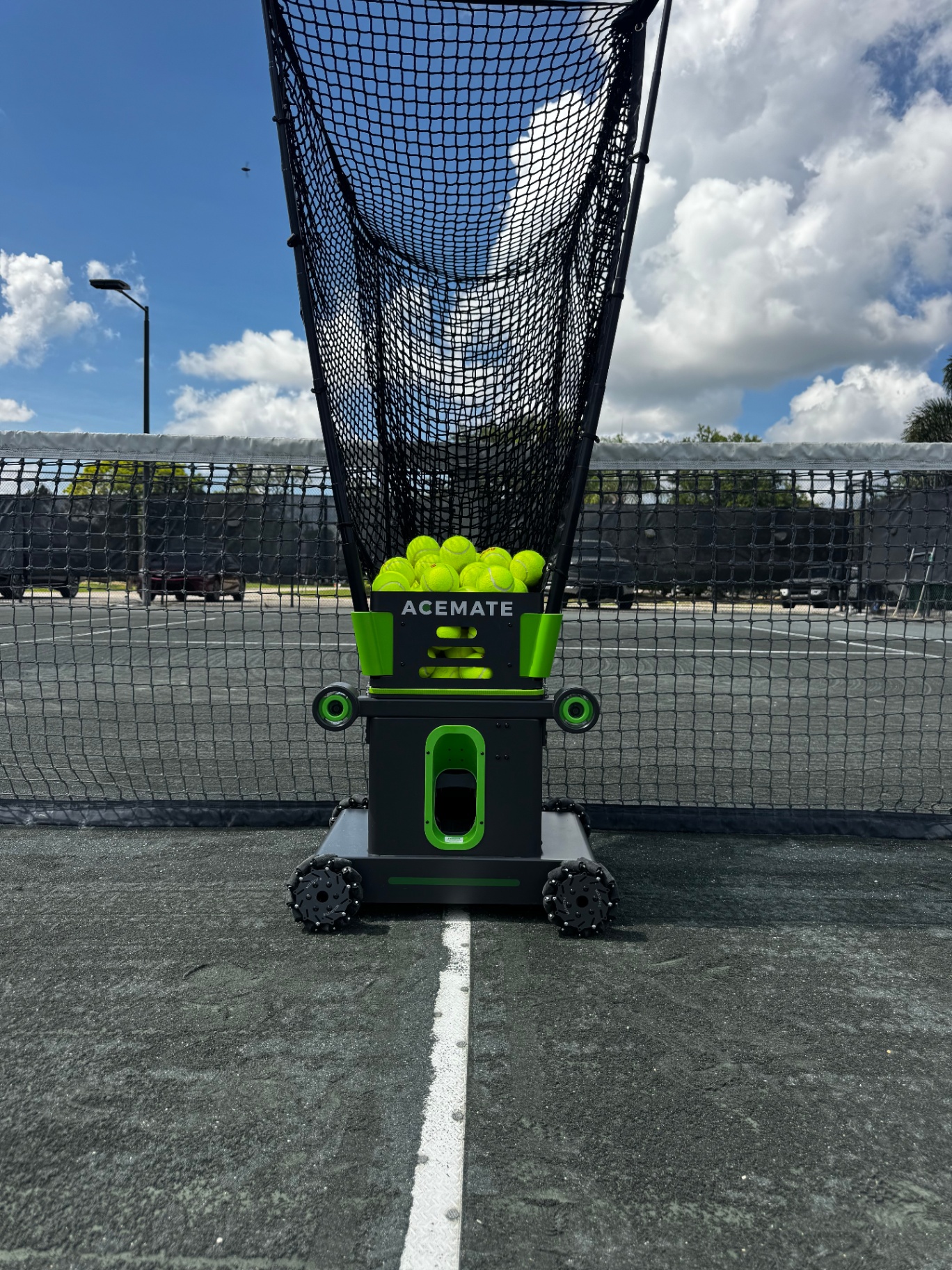 Acemate tennis ball machine loaded with balls on a UTC Har-Tru court in Fort Myers
